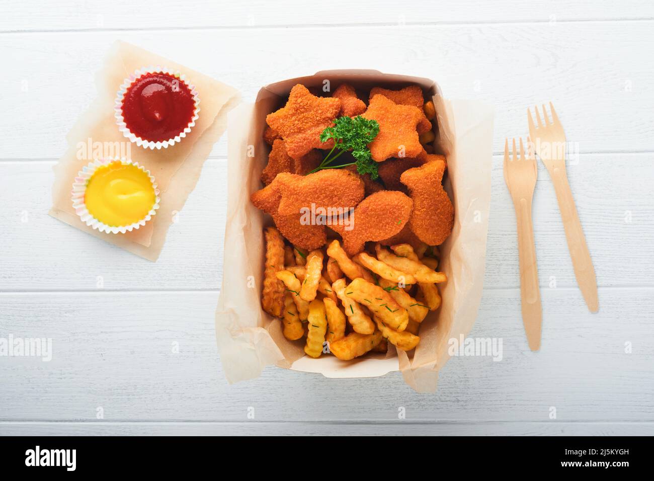 Fish and Chips, restauration rapide britannique. Bâtonnets de poisson avec frites sur une assiette en papier à emporter sur fond en bois blanc. Authentique britannique traditionnel Banque D'Images