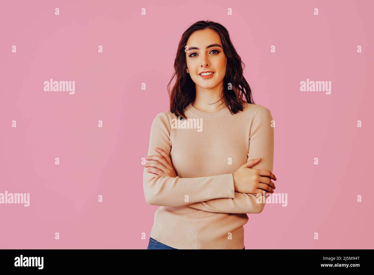 Femme brune souriante avec bras croisés regardant la caméra. Style de vie espace copie brunette Banque D'Images