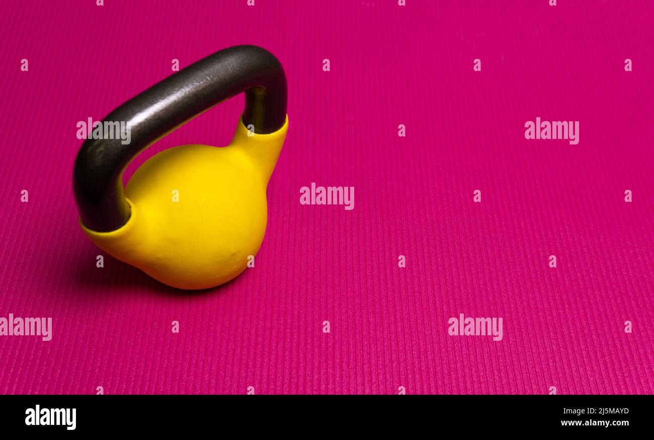 Tapis espace kettlebell yoga fond jaune sport exercice de force, pour l'entraînement de forme physique de la perte de bois, coloré lourd. Motivation Banque D'Images