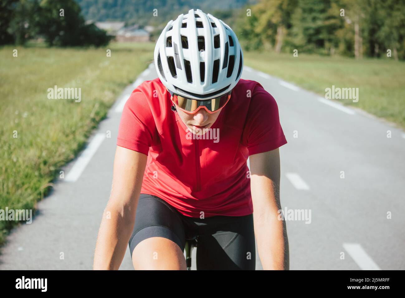 Jeune femme cycliste professionnelle en effort maximal pendant une course ascendante Banque D'Images