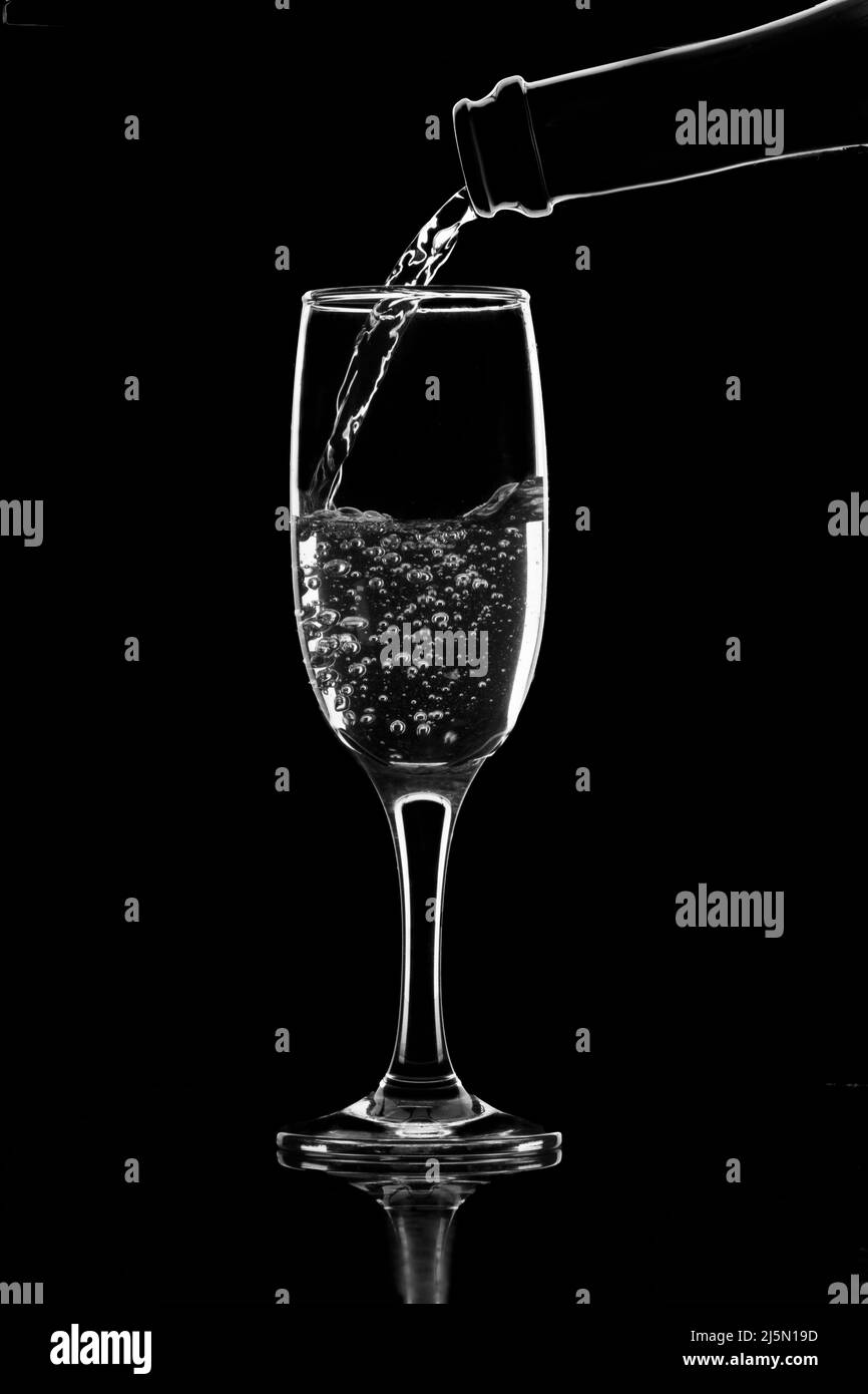 Bouteille de champagne et silhouette en verre, fond noir isolé. Banque D'Images