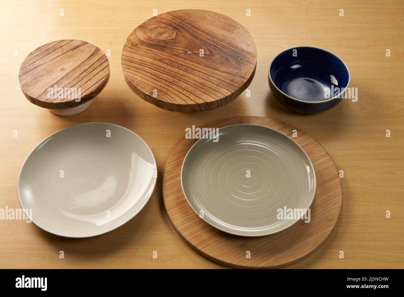 Une collection d'assiettes, de bols et d'ustensiles en bois dans une composition Banque D'Images