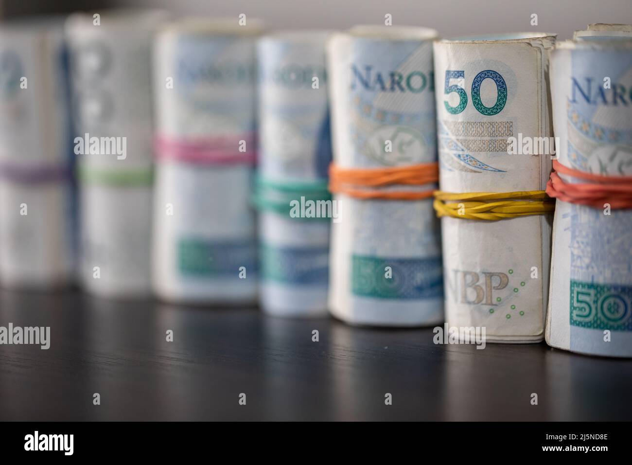 Les billets se sont roulés et attachés avec un support en caoutchouc sur le plateau de la table. Banque D'Images