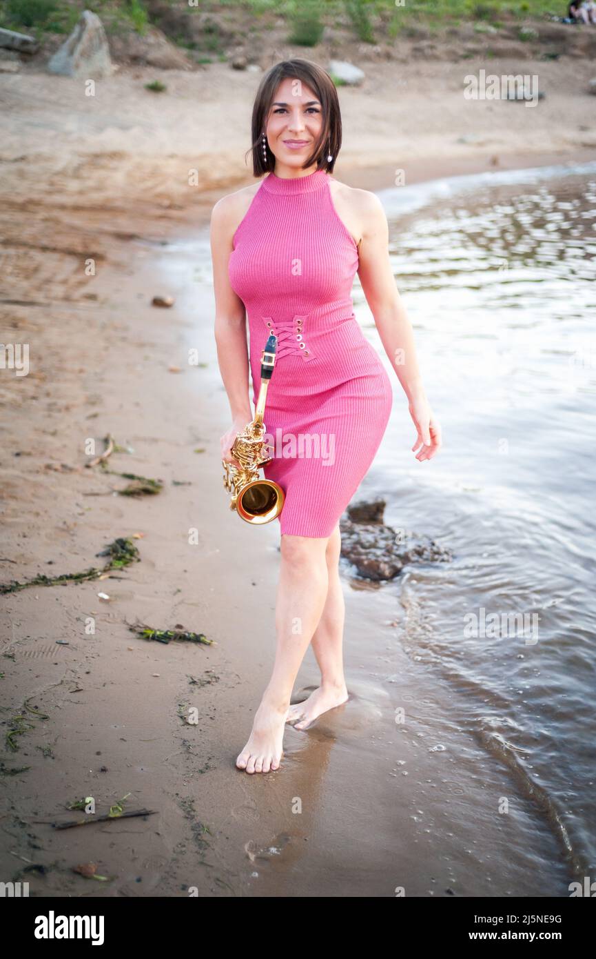 Femme jouant le saxophone au coucher du soleil Banque D'Images