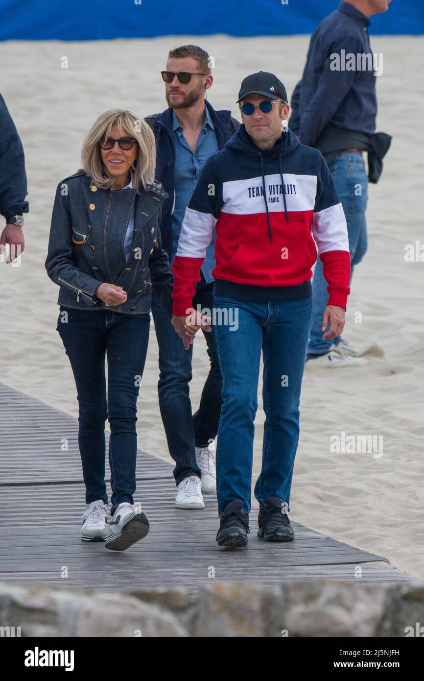 Le président français Emmanuel Macron et l'épouse Brigitte Macron marchent  sur la plage un jour avant le vote du deuxième tour des élections  présidentielles françaises au Touquet, au nord de la France,