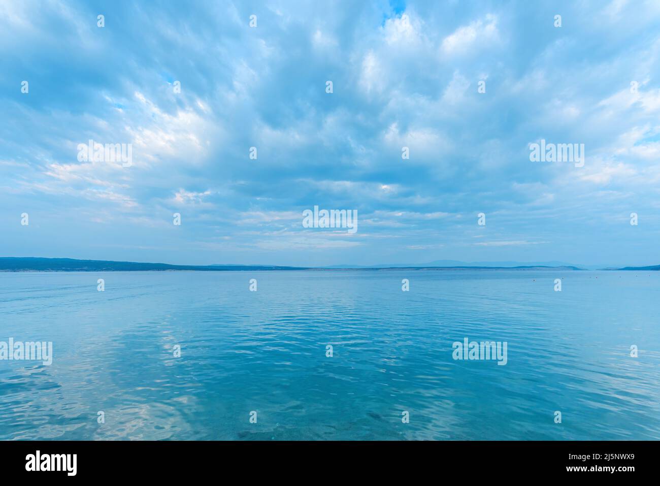 Surface d'eau de mer tranquille avec reflet ondulé des nuages et du ciel comme fond naturel Banque D'Images