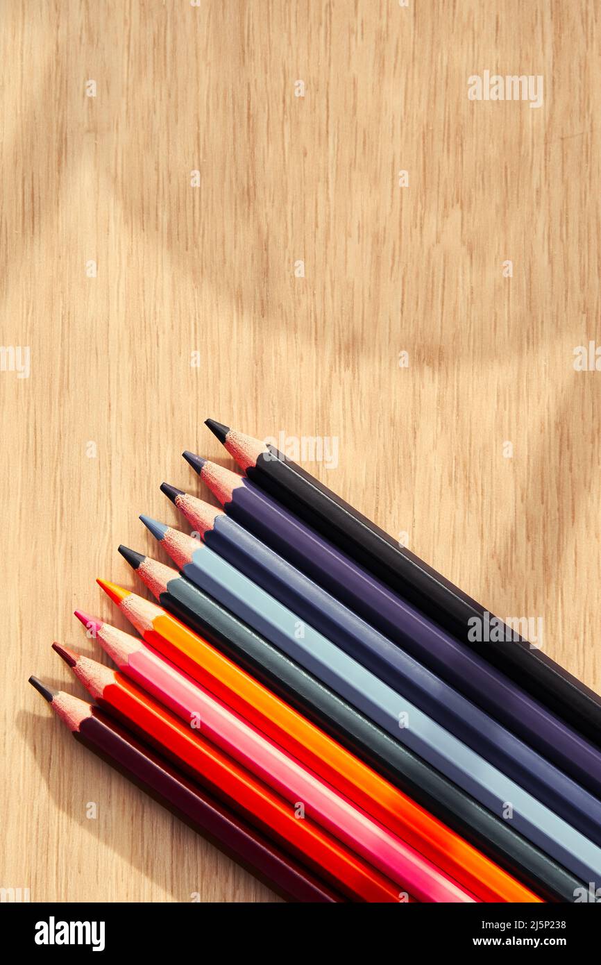 Crayons de couleur sombre sur la table en bois. Activités artistiques et de loisirs et arrière-plan vertical de loisir avec espace de copie Banque D'Images