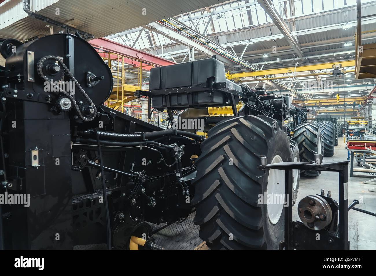 Ligne de convoyeur pour la production et l'assemblage de grandes machines industrielles, de tracteurs ou de moissonneuses-batteuses avec pneus en caoutchouc en usine. Banque D'Images