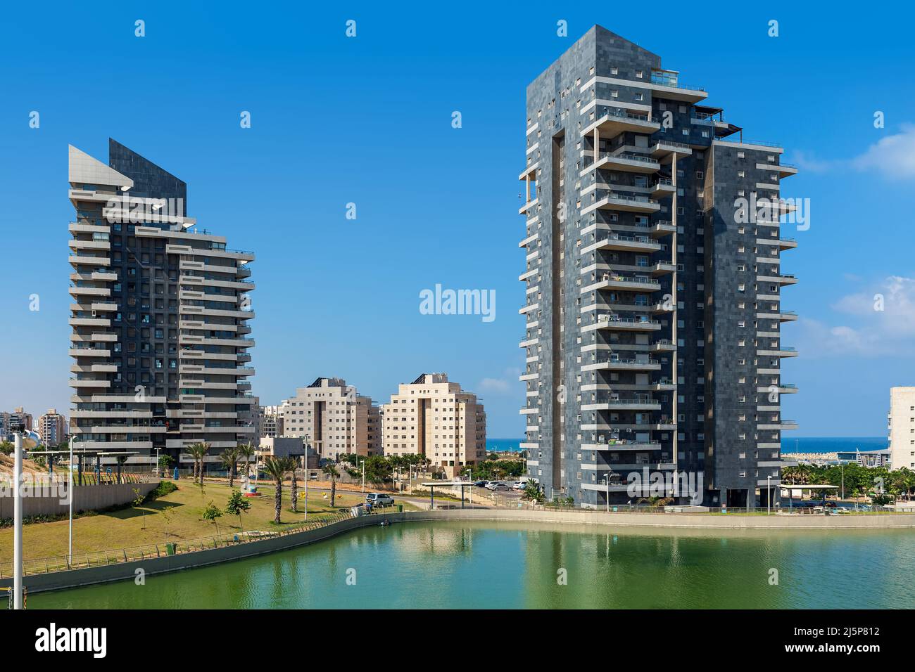 Petit lac artificiel et bâtiments résidentiels modernes de haute hauteur sous ciel bleu à Ashdod, Israël. Banque D'Images