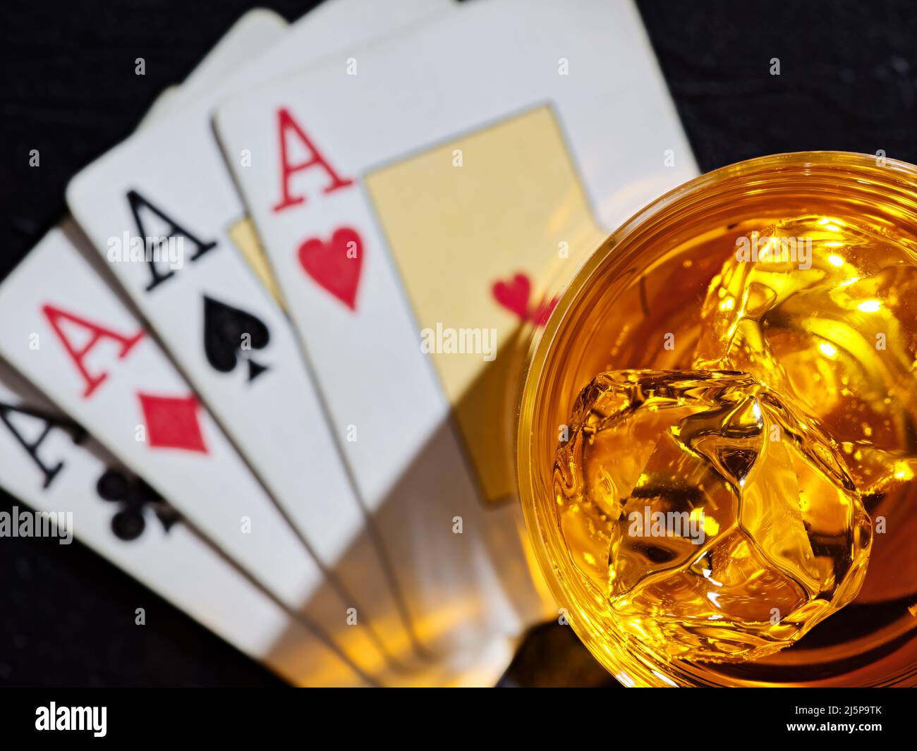 Verre de whisky avec glaçons sur les cartes de poker à quatre as. Jeu de poker et concept de whisky. Banque D'Images