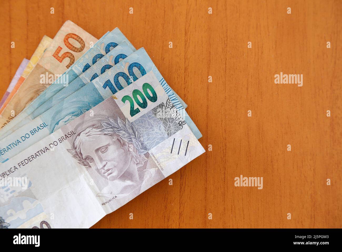 Billets d'argent brésiliens sur une surface en bois - espace de copie Banque D'Images