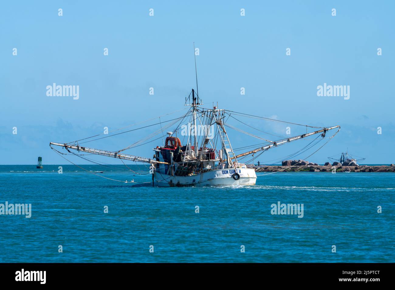 Un bateau commercial de crevettes part voir à travers le chenal de Brownsville à côté de South Padre Island, Texas. Banque D'Images