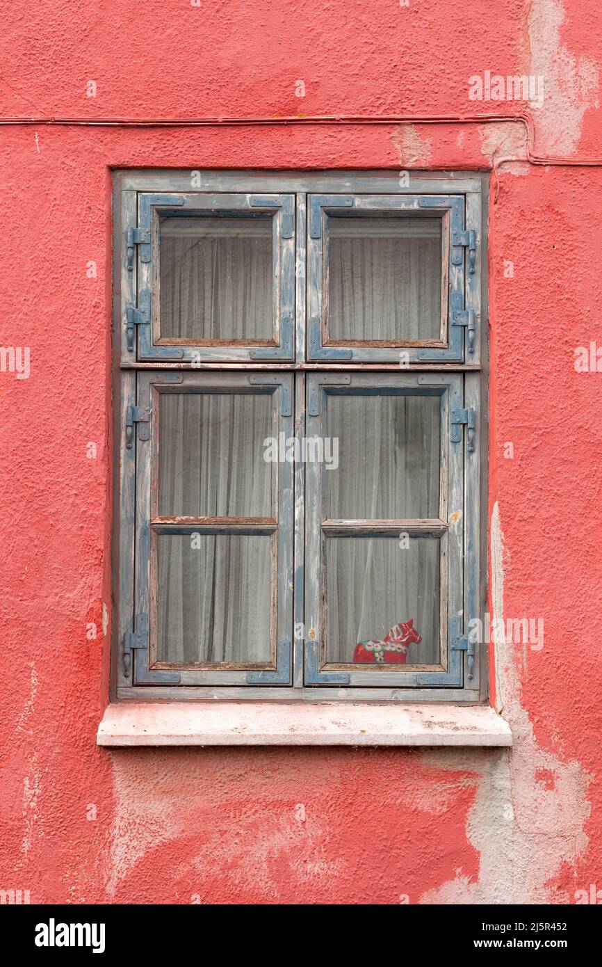 Fenêtre en bois bleu sur le mur rouge Banque D'Images