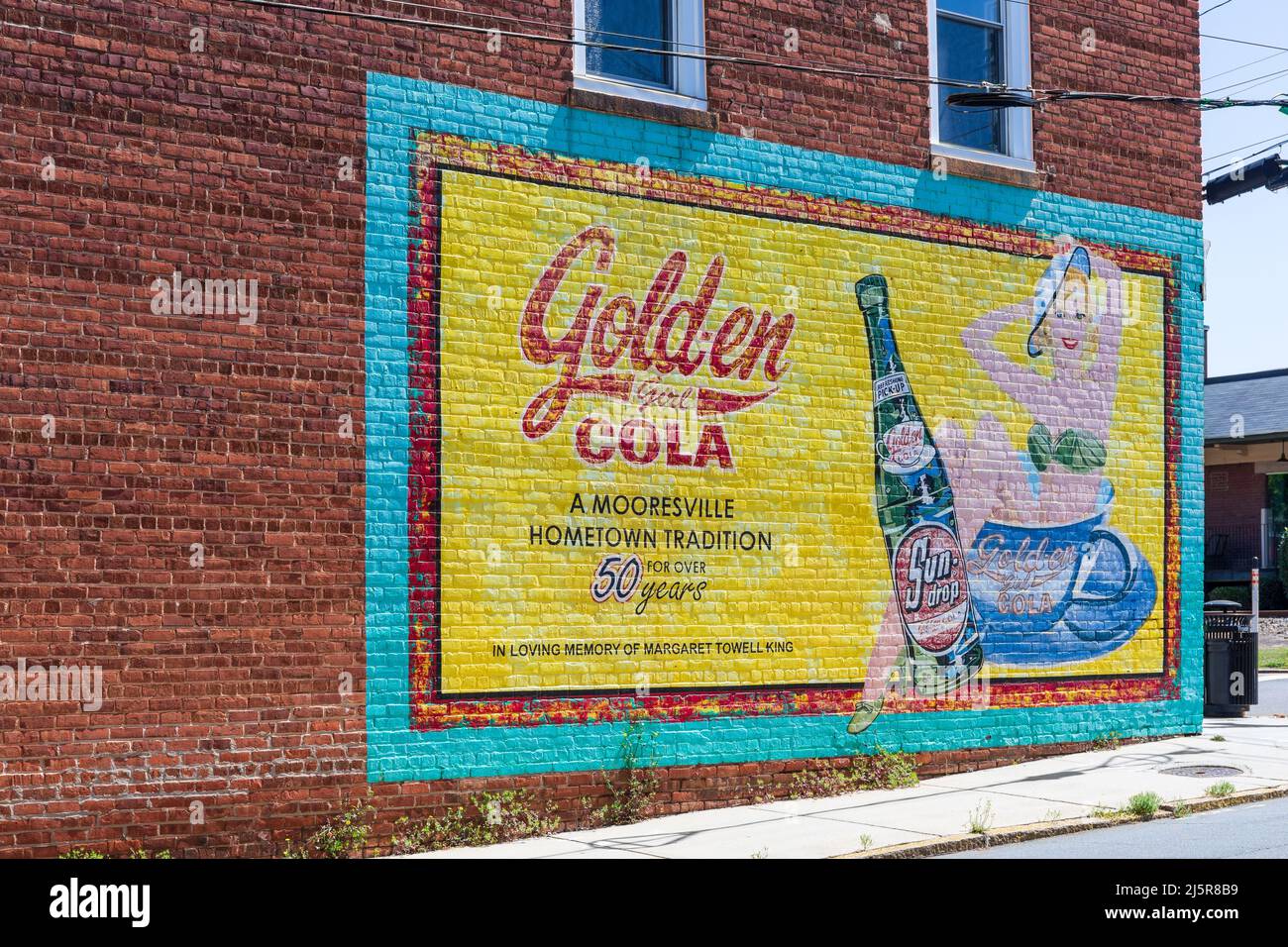 MOORESVILLE, NC, USA-17 AVRIL 2022: Un panneau peint historique de publicité pour Sun-Drop cola, Golden Girl Cola, 'a Mooresville Hometown Tradition for OV Banque D'Images