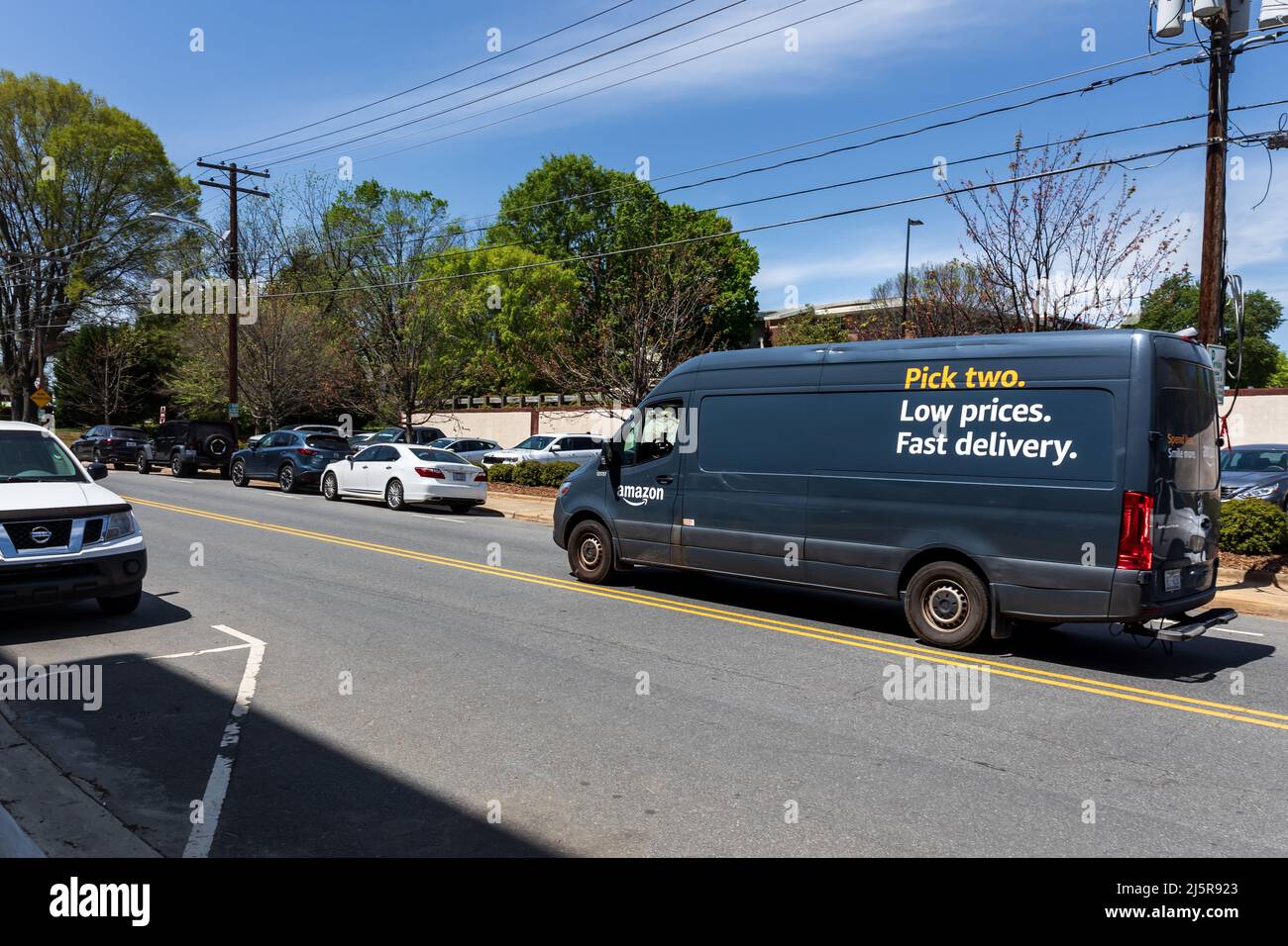 MOORESVILLE, NC, USA-17 AVRIL 2022 : un minibus de livraison Amazon qui traverse le centre-ville. Banque D'Images