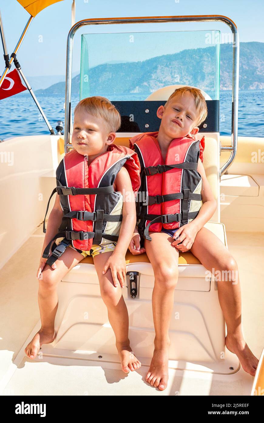 Les frères blonds en gilets de sauvetage se sentent ennuyé voile dans la mer à l'excursion en bateau à Marmaris. Les tout-petits et les garçons d'âge préscolaire en vacances d'été en Turquie Banque D'Images