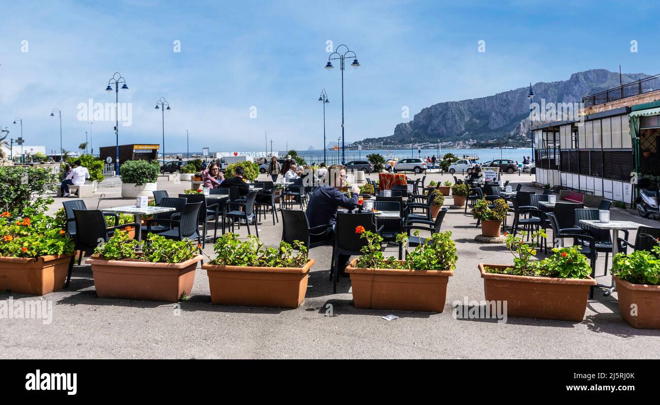 Les gens mangent dans un restaurant près du front de mer dans le village de Mondello, Sicile, Italie. Banque D'Images