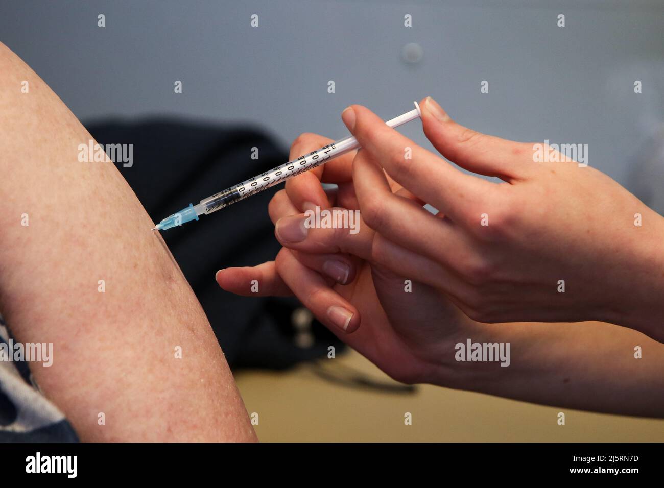 Londres, Royaume-Uni. 22nd avril 2022. Un travailleur de la santé administre le rappel COVID-19 du printemps, également connu sous le nom de quatrième jab, à une personne dans une clinique de vaccination. Crédit : SOPA Images Limited/Alamy Live News Banque D'Images