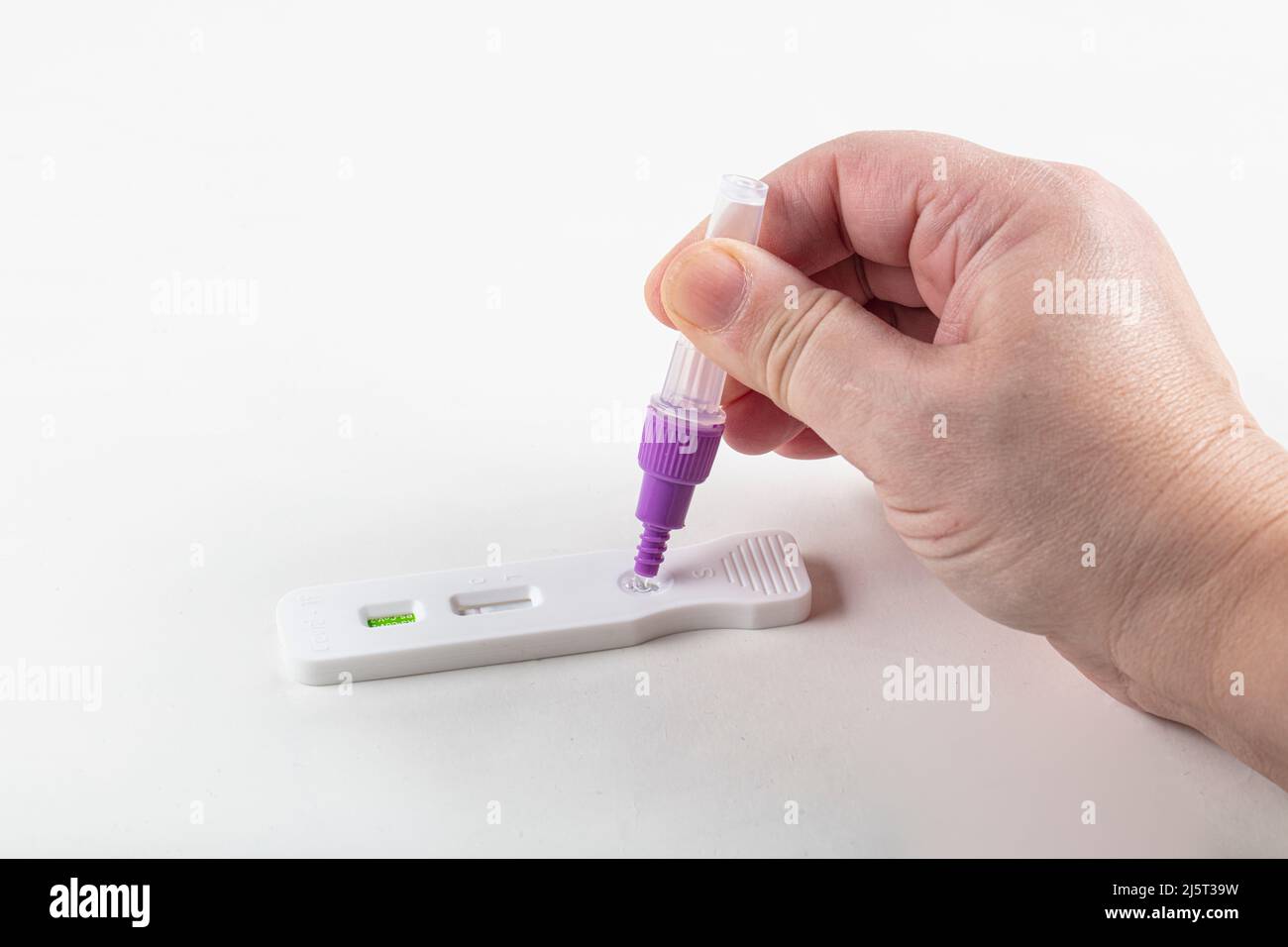 Kit nasal de test rapide de l'antigène du coronavirus ATK SRAS COV 2. Une femme effectuant un auto-test pour Covid-19 à la maison. Test de main sur fond blanc. Covid- Banque D'Images