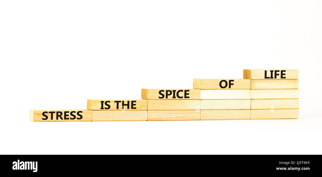 Symbole d'épice de stress de la vie. Concept mots le stress est l'épice de la vie sur des blocs de bois. Magnifique table blanche fond blanc. Motivation de l'entreprise Banque D'Images