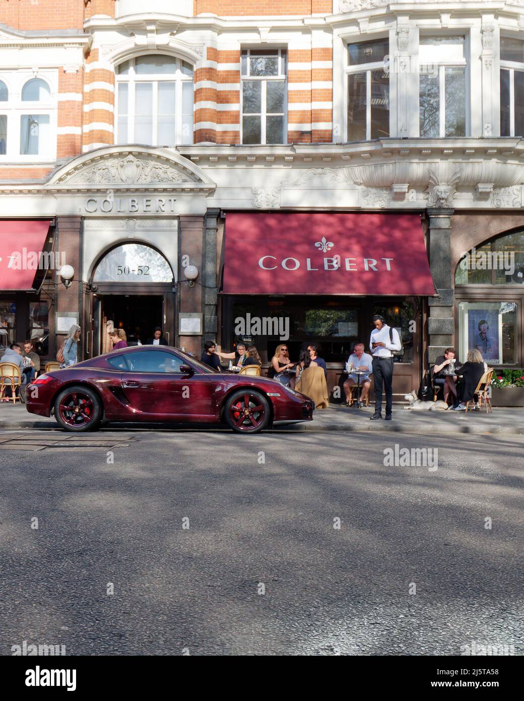 Londres, Grand Londres, Angleterre, avril 16 2022 : Porsche pourpre garée à l'extérieur de Colbert, un café restaurant français à Sloane Square avec un auvent pourpre. Banque D'Images