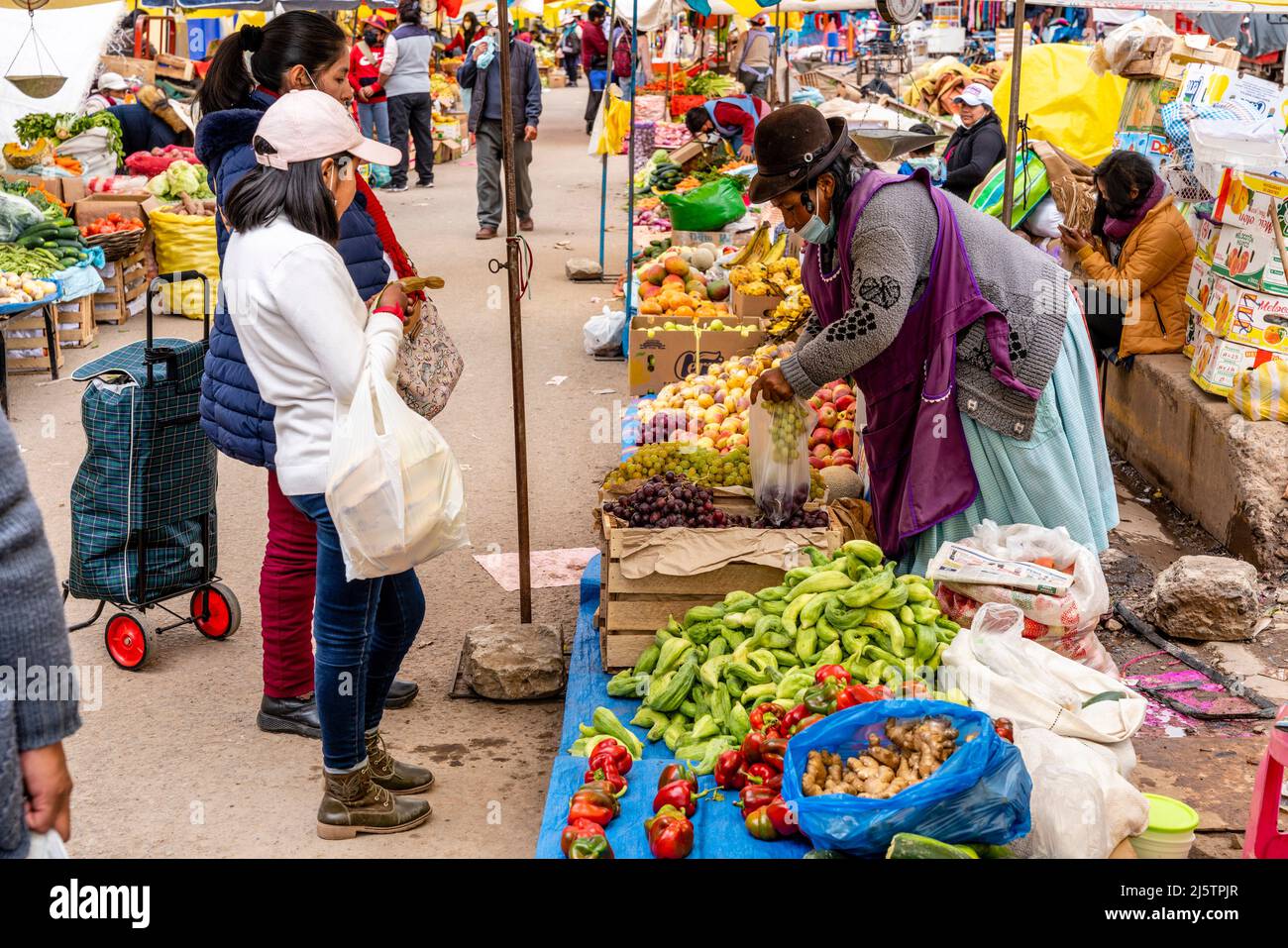 Les femmes de la région achètent des fruits et des légumes à Un marché de rue, Puno, province de Puno, Pérou. Banque D'Images