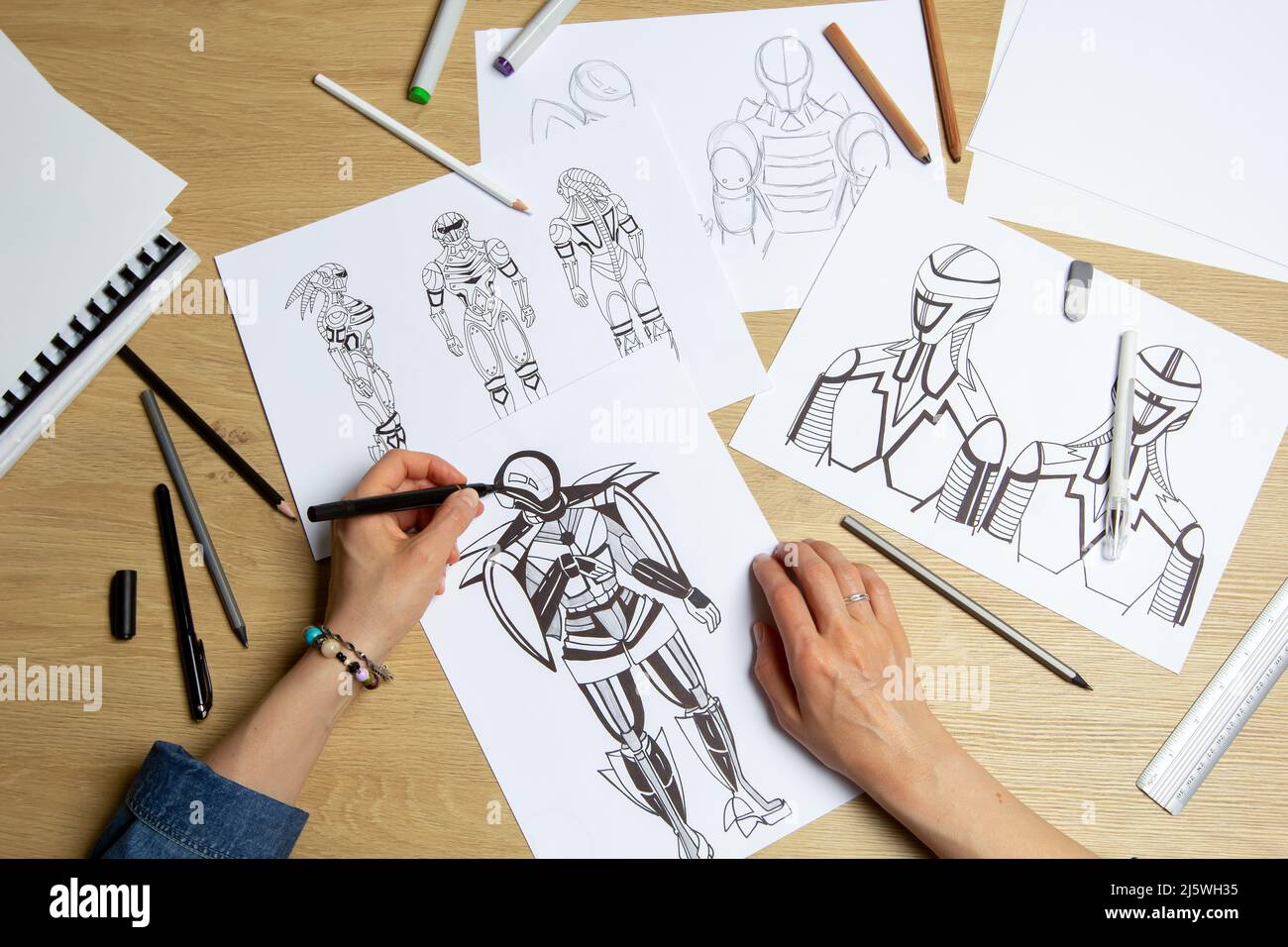 Concept art. L'artiste dessine des croquis de robots cyborg sur papier. Conception de personnages pour un jeu vidéo. Création d'animation. Banque D'Images