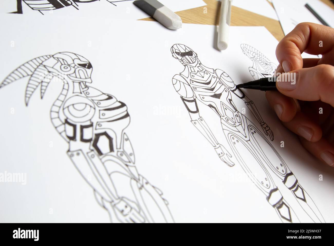 Concept art. L'artiste dessine des croquis de robots cyborg sur papier. Conception de personnages pour un jeu vidéo. Création d'animation. Banque D'Images