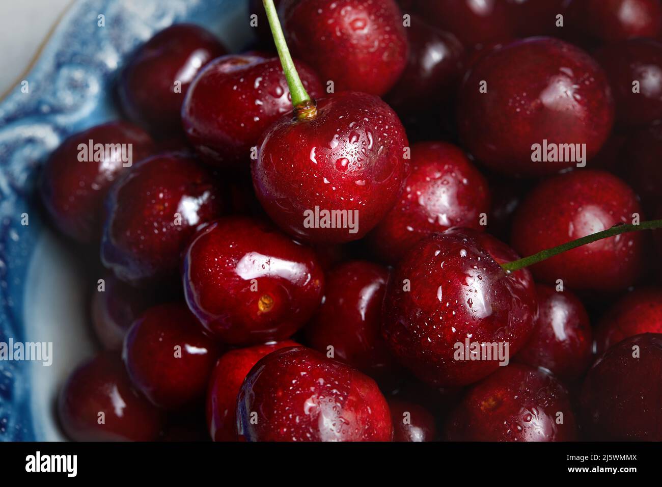 Gros plan sur une pile de cerises mûres. Cerises rouges fraîches. Fond de cerises mûres Banque D'Images