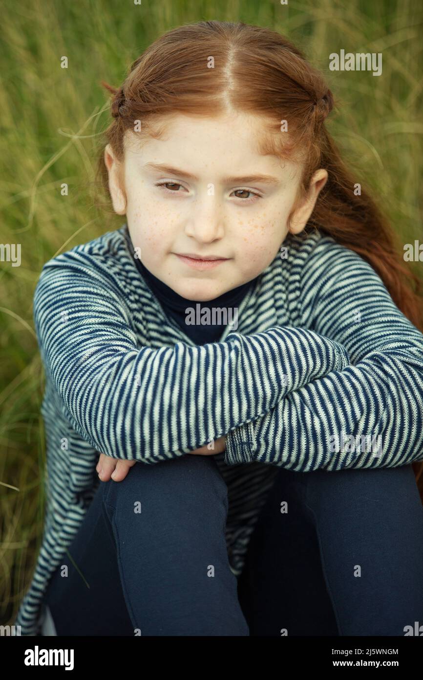 Belle fille à tête rouge qui regarde loin dehors Banque D'Images