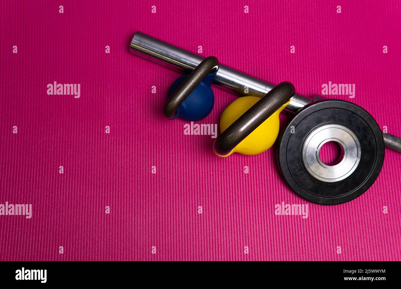 Rod jaune sport poids rouge bleu vert barbell en acier, de l'entraînement haltères pour la santé pour la serviette de chambre, voir levage. Personne de club d'étage, noir Banque D'Images