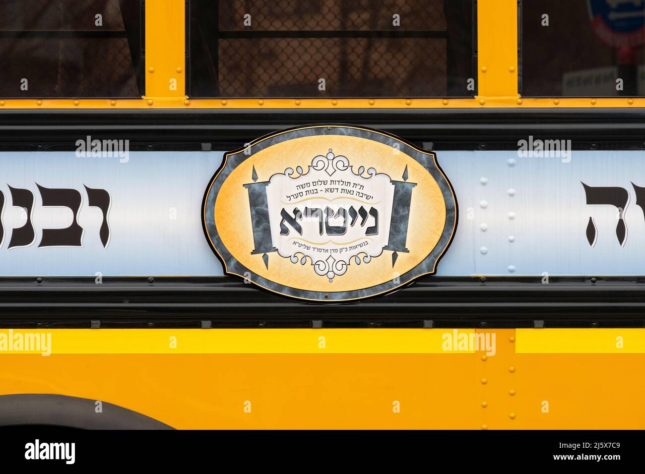 Un bus scolaire avec un logo en hébreu pour le groupe juif Nitra Hasidic. À Williamsburg, Brooklyn, New York. Banque D'Images
