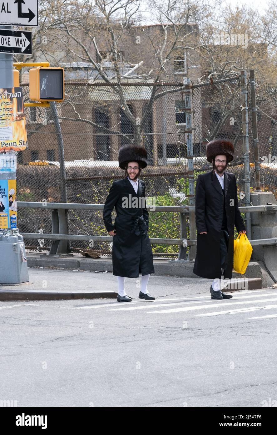 Deux hommes juifs orthodoxes marchent sur Lee ave à Williamsburg en portant  des chapeaux en fourrure de shtreimel et des bas blancs hauts. Sur la Pâque  à Brooklyn, New York Photo Stock -