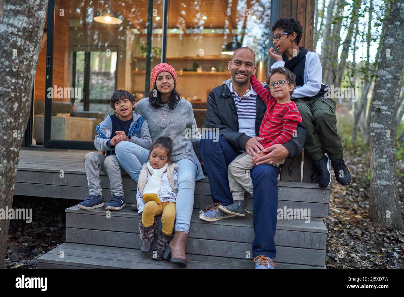 Portrait de famille heureuse sur les marches de location de maison Banque D'Images