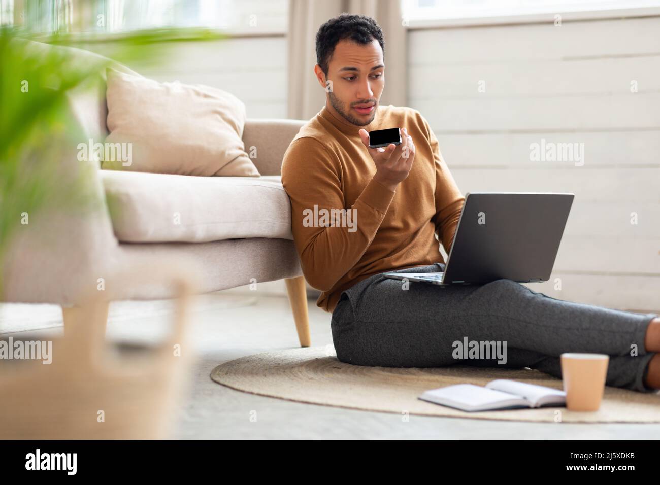 Homme concentré travaillant et parlant au téléphone au bureau à domicile Banque D'Images