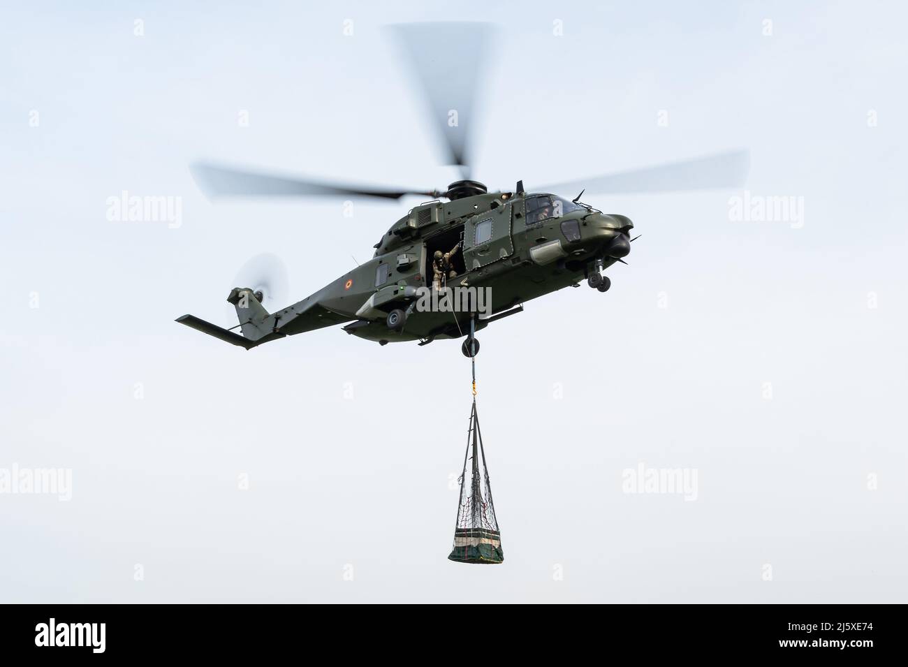Un hélicoptère NHIndustries NH90 TTH de l'Armée de l'Air belge effectuant des opérations de chargement par limonage au cours d'un exercice militaire. Banque D'Images