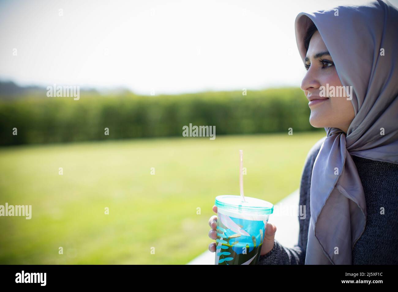 Jeune femme en foulard boire du jus Banque D'Images