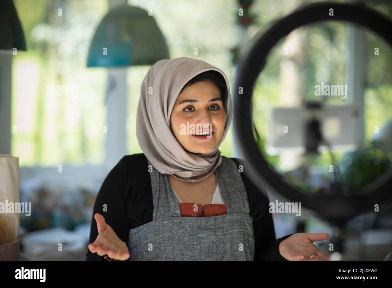 Jeune influenceur féminin dans la vlogging de hijab en studio Banque D'Images