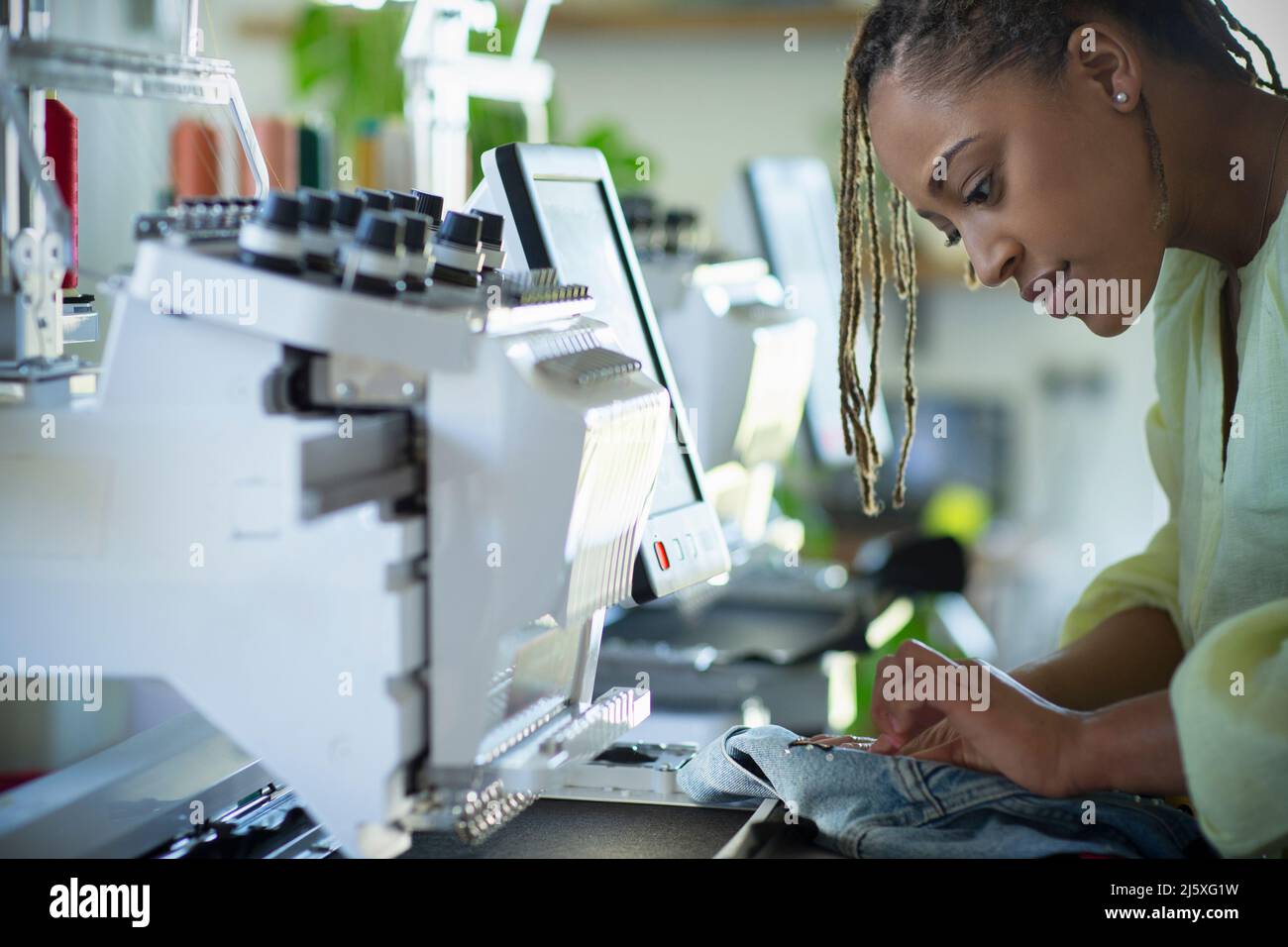 Jeune femme couturière travaillant à la machine à coudre Banque D'Images