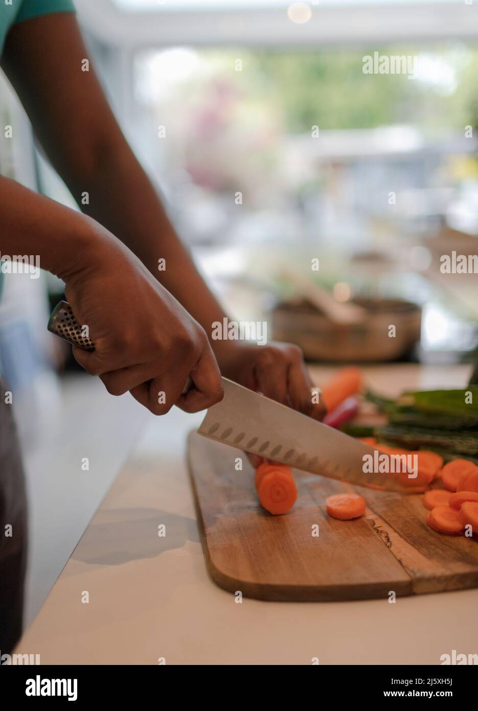 Gros plan sur la planche à découper avec un couteau à boucher pour trancher les carottes Banque D'Images