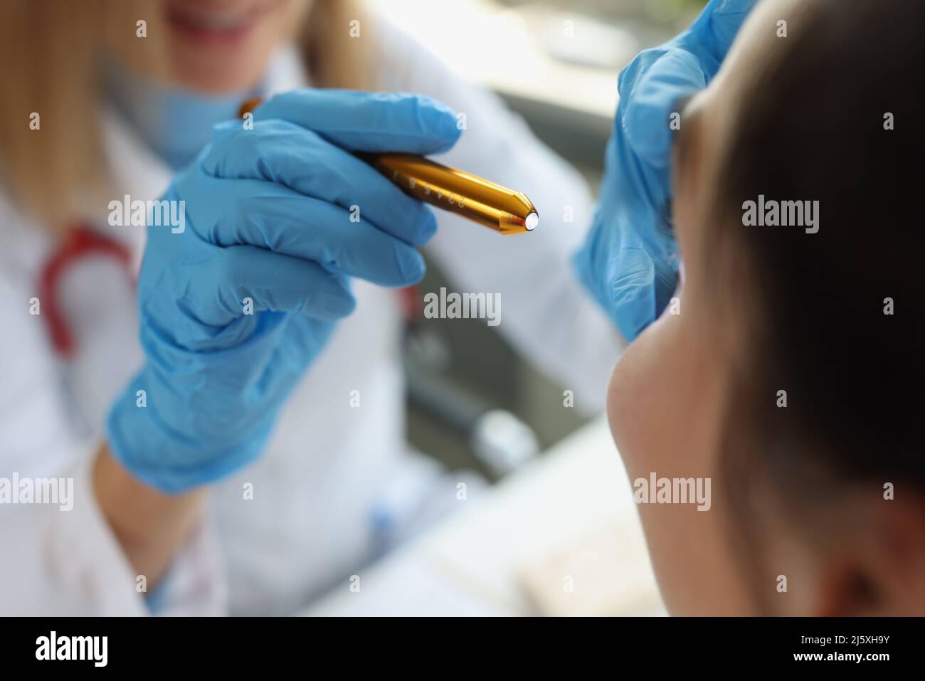 Médecin neurologue brillant la lampe de poche sur les yeux du patient dans la clinique de près Banque D'Images