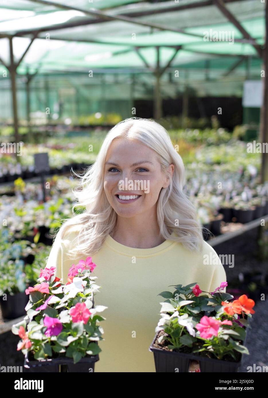 Portrait bonne femme shopping pour des fleurs en pot dans la boutique de jardin Banque D'Images