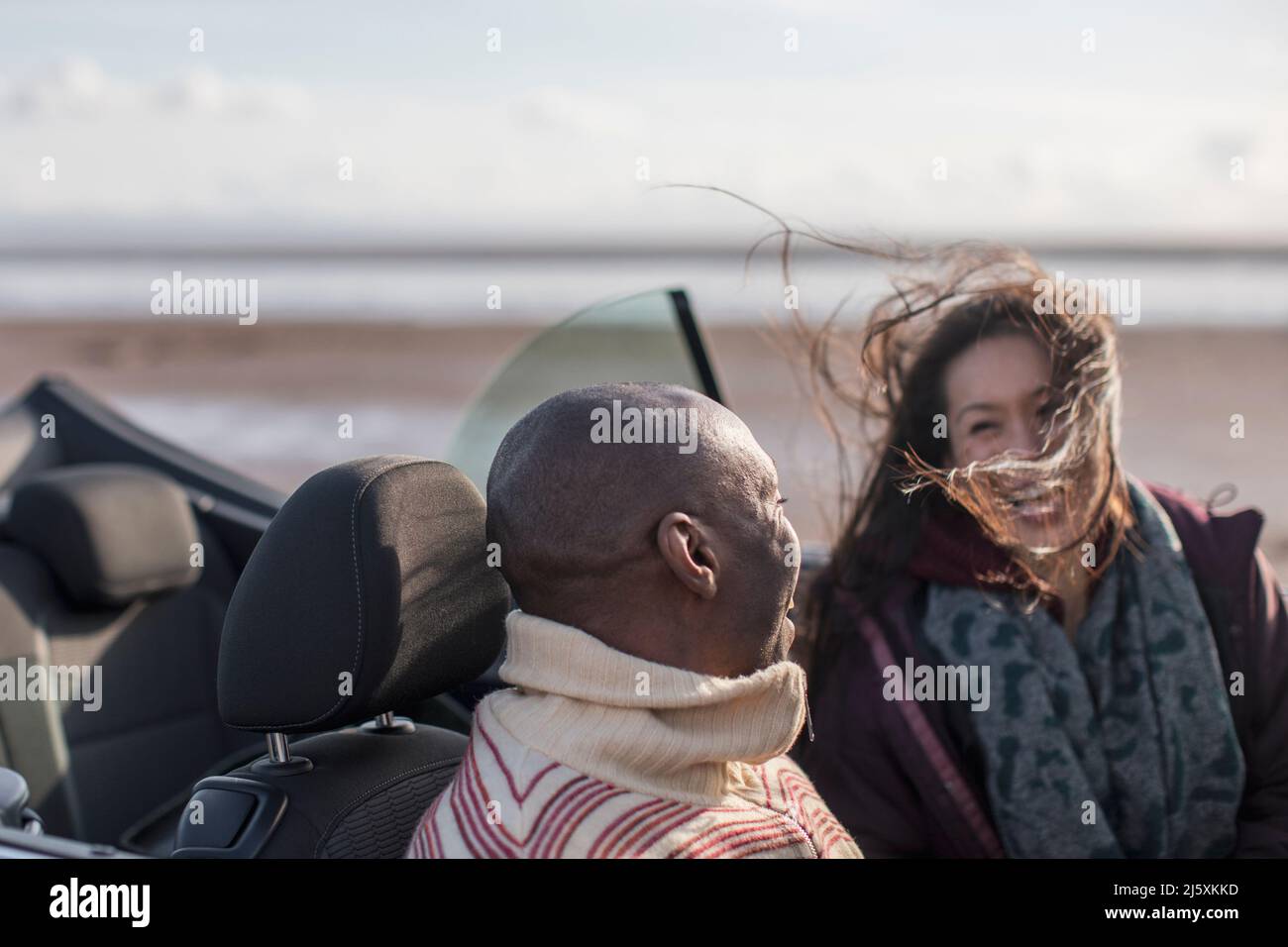 Un couple heureux dans un cabriolet venteux Banque D'Images