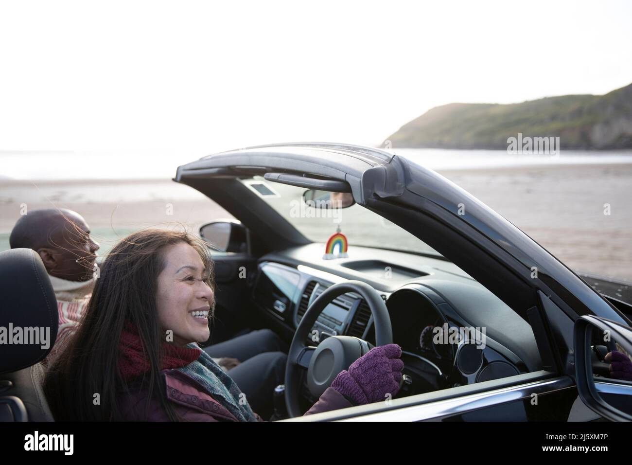 Couple heureux en voiture convertible sur la plage d'hiver Banque D'Images