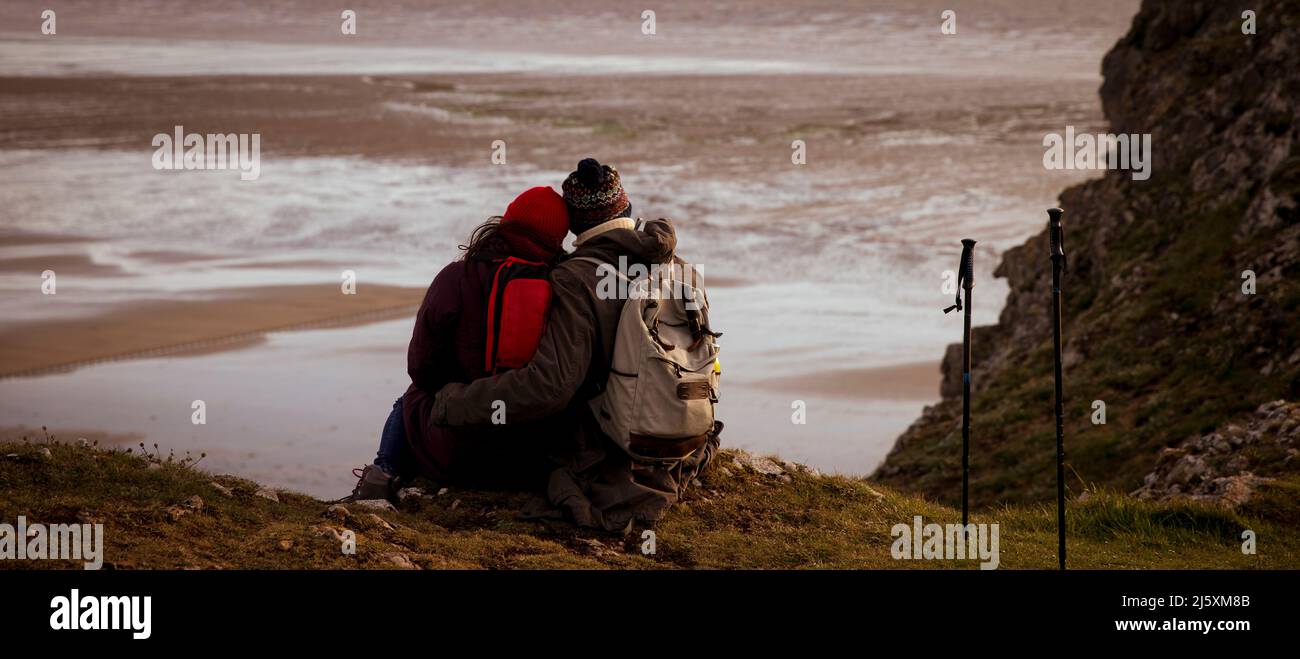Couple de randonneurs affectueux sur la falaise au-dessus de la plage d'hiver Banque D'Images