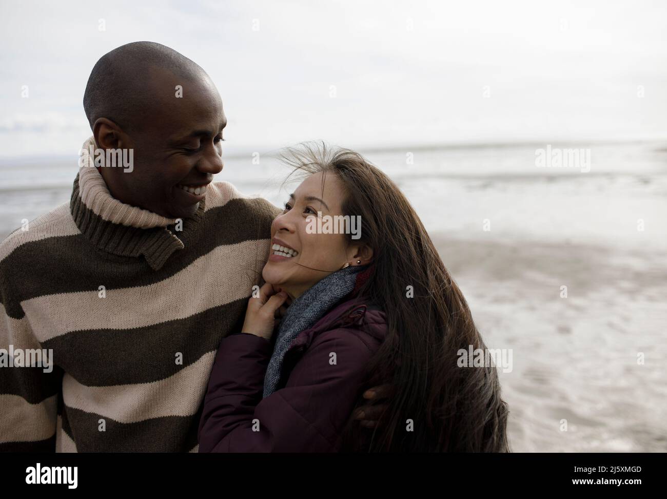 Heureux couple hugging on winter beach Banque D'Images