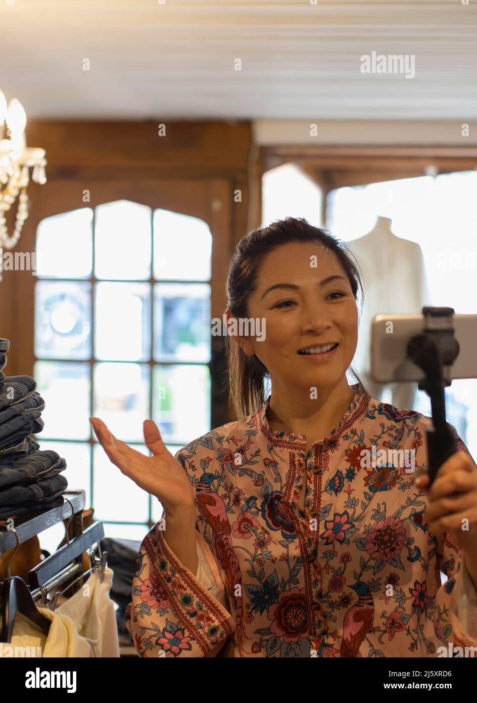 Une femme propriétaire de boutique vlogging avec smartphone dans la boutique Banque D'Images