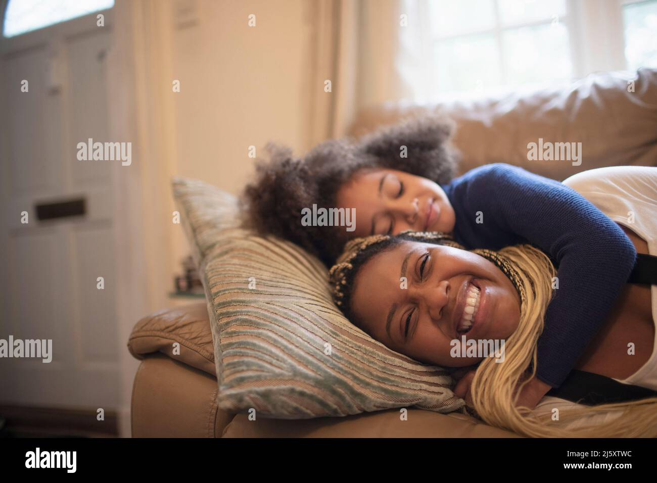 Bonne mère et fille se câliner sur le canapé du salon Banque D'Images