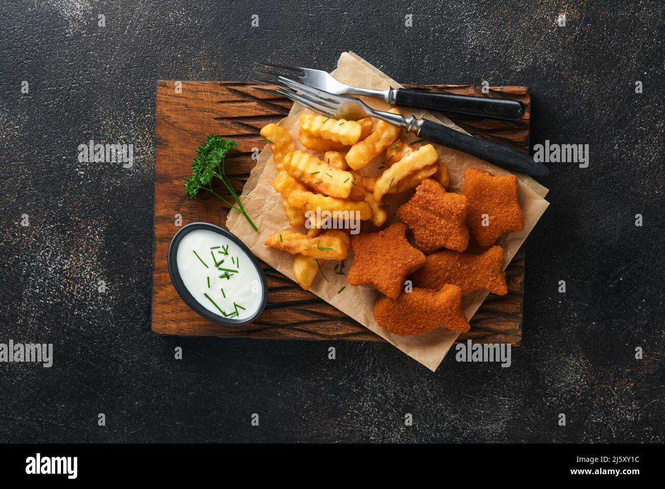 Fish and Chips, restauration rapide britannique. Bâtonnets de poisson avec frites sur un panneau rustique sur fond de vieux béton foncé. Traditionnelle britannique authentique str Banque D'Images