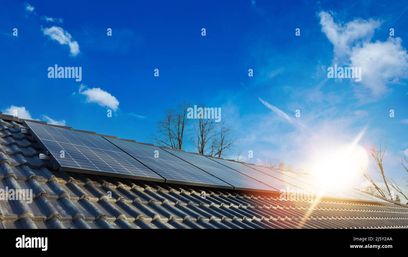 Soleil lumineux sur le système solaire moderne sur le toit de la maison comme énergie renouvelable Banque D'Images